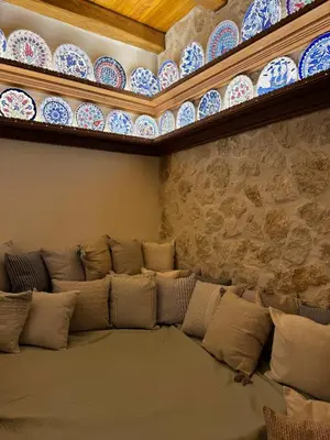 a room with a couch with plates on the wall at Aetheria Traditional House 2 in Koskinou
