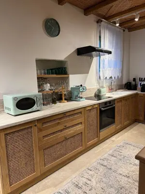 a kitchen with wooden cabinets and a sink and a microwave at Aetheria Traditional House 2 in Koskinou