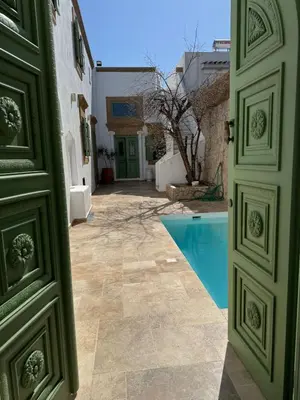 an open door to a courtyard with a swimming pool at Aetheria Traditional House 2 in Koskinou