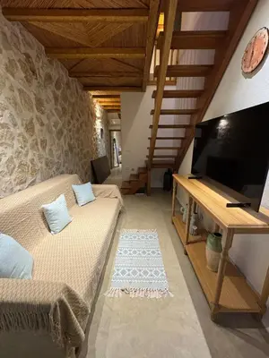 a room with two beds and a flat screen tv at Aetheria Traditional House 2 in Koskinou