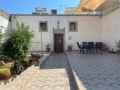 a house with a patio with a table and chairs at Kamara Cottage - Traditional Stone House in Malona Village