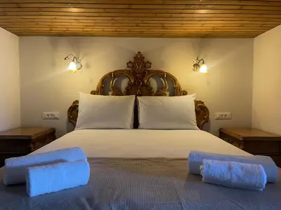 a bedroom with a bed with two towels on it at Kamara Cottage - Traditional Stone House in Malona Village