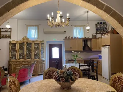 a kitchen and dining room with a table and a chandelier at Kamara Cottage - Traditional Stone House in Malona Village