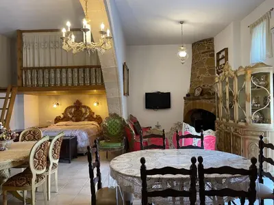 a bedroom with a bed and a table and chairs at Kamara Cottage - Traditional Stone House in Malona Village