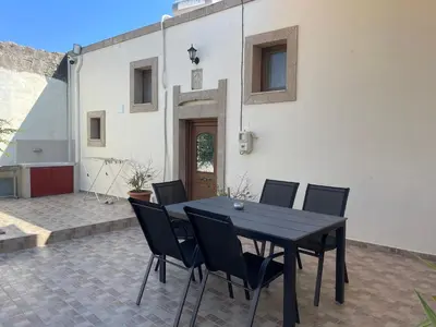 a black table and chairs on a patio at Kamara Cottage - Traditional Stone House in Malona Village
