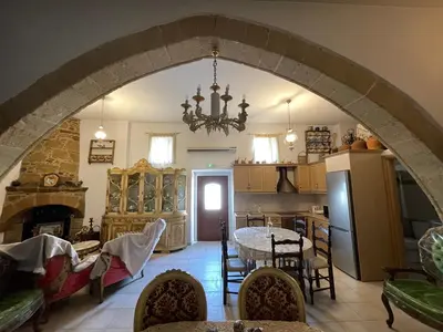 a kitchen and a dining room with an archway at Kamara Cottage - Traditional Stone House in Malona Village