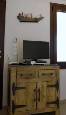 a wooden dresser with a television on top of it at Eleni Boutique Apartment in Líndos