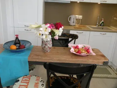 a kitchen with a table with a vase of flowers and fruit at Eleni Boutique Apartment in Líndos