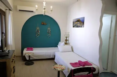 a bedroom with two beds and a blue wall at Eleni Boutique Apartment in Líndos