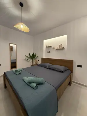 a bedroom with a large bed with a blue blanket at Meraki Apartment in Kremasti