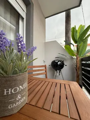 a wooden table with purple flowers on a balcony at Meraki Apartment in Kremasti