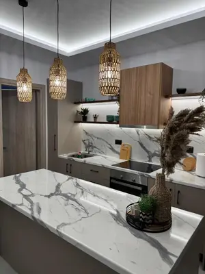 a kitchen with a marble counter top and pendant lights at Meraki Apartment in Kremasti