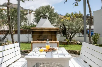 a white table with a plate of food and orange juice at Ennisfree Villa in Kiotari