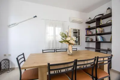 a dining room table with chairs and a vase with flowers at Ennisfree Villa in Kiotari