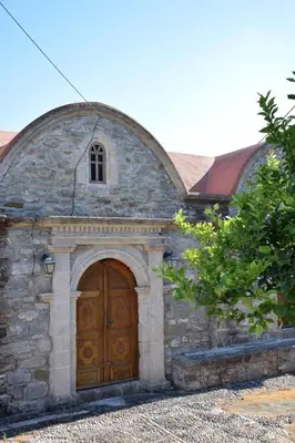 a stone building with a large wooden door at Laertis Studio in Kattavía