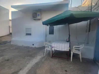a table and chairs under a green umbrella at Laertis Studio in Kattavía