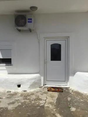 a white door in a white wall with a fan at Laertis Studio in Kattavía