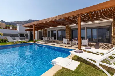 a villa with a swimming pool and a house at Lindia Athena Luxury Villas in Líndos