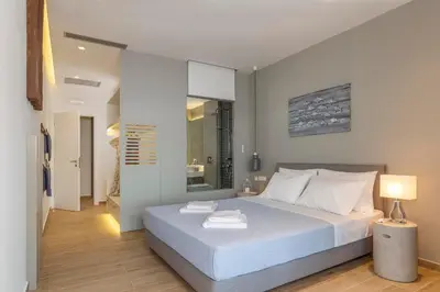 a bedroom with a large white bed and a lamp at Lindia Athena Luxury Villas in Líndos