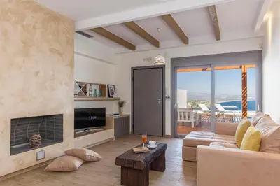 a living room with a couch and a fireplace at Lindia Athena Luxury Villas in Líndos