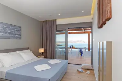 a bedroom with a bed and a view of the ocean at Lindia Athena Luxury Villas in Líndos