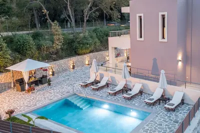 an image of a swimming pool with chairs and umbrellas at Oasis Luxury Villa in Rhodes Town