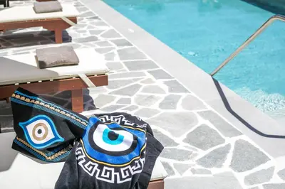 a purse sitting next to a swimming pool at Oasis Luxury Villa in Rhodes Town