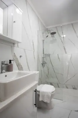 a white bathroom with a sink and a toilet at Oasis Luxury Villa in Rhodes Town