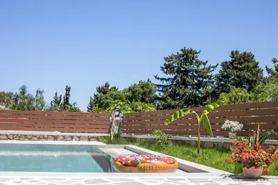 a swimming pool in a yard with a wooden fence at Oasis Luxury Villa in Rhodes Town