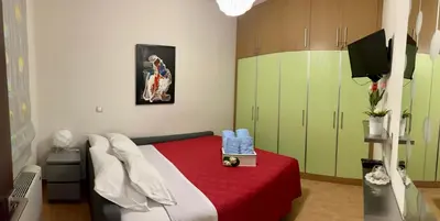 a bedroom with a bed with a red blanket and green cabinets at Lindos Anatoli Luxury Villa in Líndos