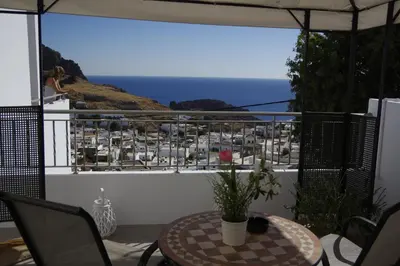 a balcony with a table and a view of the ocean at Lindos Anatoli Luxury Villa in Líndos