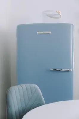 a blue chair in front of a desk at Leoni's House near the Beach in Kremasti