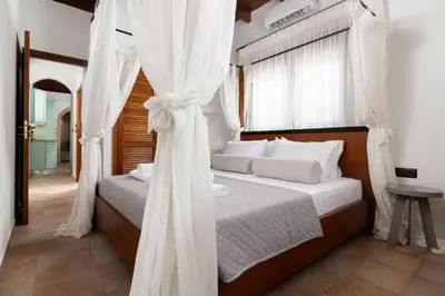 a bedroom with a bed with white curtains at Casa della Nonna Rhodes in Gennadi