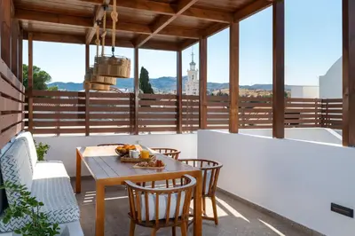 a patio with a wooden table and chairs on a balcony at Casa della Nonna Rhodes in Gennadi