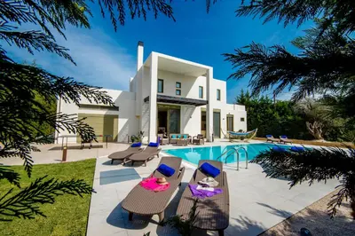 a villa with a swimming pool and a house at Filerimos Oasis Villa in Ialyssos