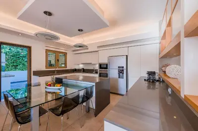 a large kitchen with a glass table and chairs at Filerimos Oasis Villa in Ialyssos