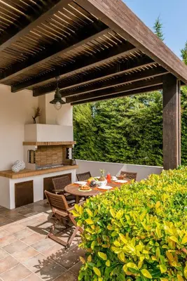 a patio with a wooden pergola and a table at Filerimos Oasis Villa in Ialyssos