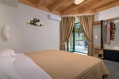 a bedroom with a bed and a large window at ElaionHill-villa in Gennadi