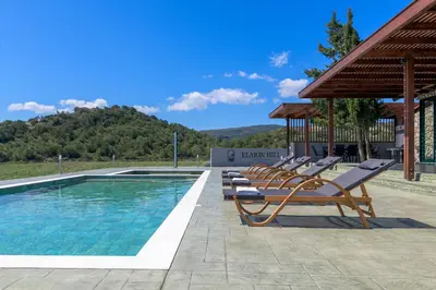 a row of lounge chairs next to a swimming pool at ElaionHill-villa in Gennadi