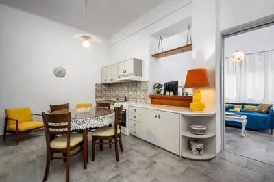 a kitchen and dining room with a table and chairs at Plumeria Apartment in Rhodes Town