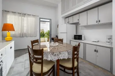 a kitchen and dining room with a table and chairs at Plumeria Apartment in Rhodes Town