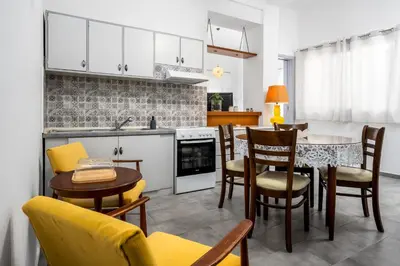 a kitchen and dining room with a table and chairs at Plumeria Apartment in Rhodes Town
