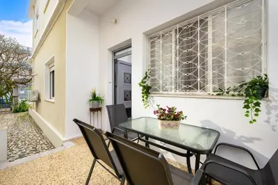 a patio with a glass table and chairs at Plumeria Apartment in Rhodes Town