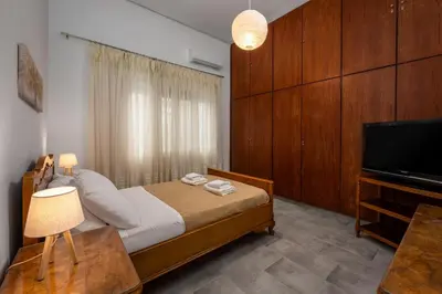 a bedroom with a bed and a flat screen tv at Plumeria Apartment in Rhodes Town
