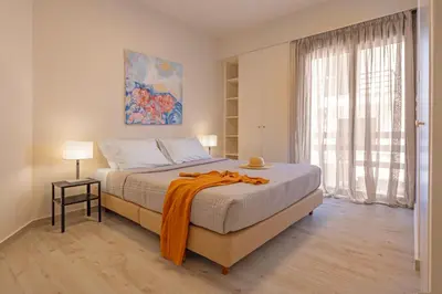 a bedroom with a bed with an orange blanket on it at City Choice 2 Live - Sofouli 15 in Rhodes Town