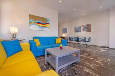 a living room with blue and yellow furniture and a table at City Choice 2 Live - Sofouli 15 in Rhodes Town