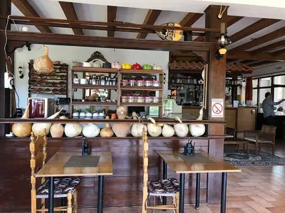 a restaurant with wooden tables and chairs and a counter at Liros in Kamiros