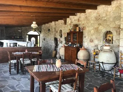 a kitchen with tables and chairs in a room at Liros in Kamiros