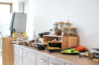 a counter with bowls of fruits and vegetables on it at Nikos BnB in Faliraki