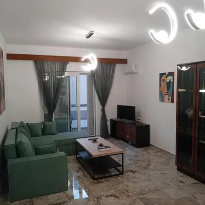 a living room with a green couch and a table at Dioni of Rhodes in Rhodes Town